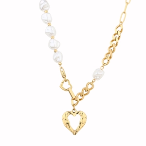 Dettaglio della collana asimmetrica con perle barocche e pendente a cuore d'oro traforato