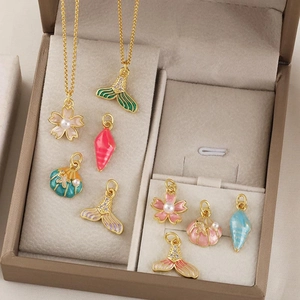 Set gioielli a tema marino con conchiglie dorate, stelle marine e ciondoli in smalto colorato
