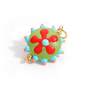 Macro detail of hand-painted glass heart pendant with colorful flower patterns and gold ring