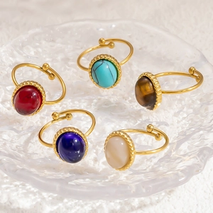 Detail of five adjustable gold-plated rings with colorful oval-cut natural stones