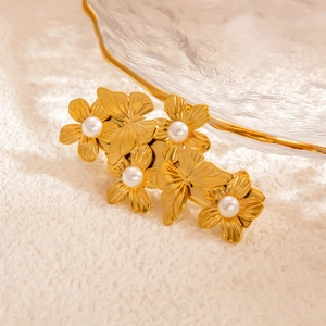 Détail de la barrette dorée avec fleurs, papillons, perles blanches et cristaux