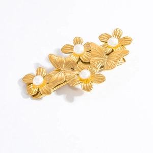 Détail de la barrette dorée avec motifs de papillons et fleurs serties de perles