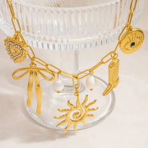 Dettaglio macro della collana placcata oro 18K con ciondoli a fiocco e perle