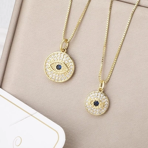 Chic gold circular evil eye pendant necklace with pave crystals and blue center stone