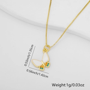 Macro view of gold butterfly pendant with white enamel wings and zircon stones details