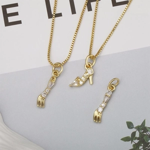 Detail of gold box chain necklace featuring sparkling rhinestone stiletto and fork pendants