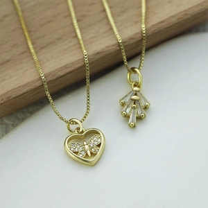 Detail of gold box chains with hollow heart butterfly and geometric fan pendants