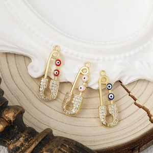 Tres colgantes de imperdible dorados con circonitas y diseño de ojo de la suerte