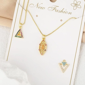 Detailansicht goldener Halskettenanhänger mit bunten Kristallverzierungen im Fokus.