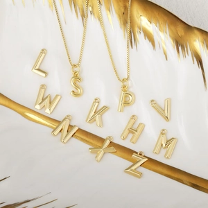 Eleganti ciondoli con lettere d'oro e superficie a rombi su un vassoio di lusso