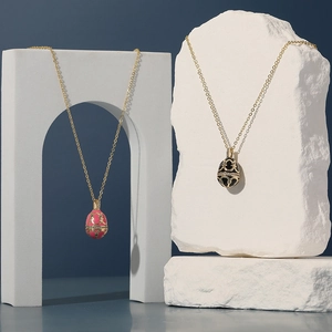 Halskette mit Faberge-Ei-Anhänger aus Emaille in Rosa und Schwarz mit Goldverzierungen