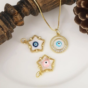 Detailed view of evil eye charms in gold finish with blue zircon stones on white tray