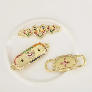 18K gold-plated micro-pave zircon connectors with heart and rainbow charms on ceramic tray