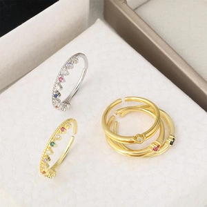 Nahaufnahme von goldenen Kronenringen und schmalen verstellbaren Ringen mit Zirkonias