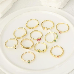 Elegante vergoldete verstellbare Ringe mit bunten Zirkonia auf einem Keramikteller präsentiert