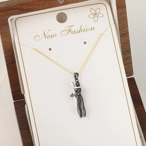 Détail macro du pendentif d'étreinte de couple sur carte dans une boîte en bois