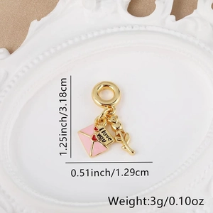 Macro detail of 18k gold plated love letter envelope pendant with pink enamel accents