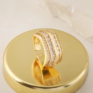 Close-up of adjustable gold-plated ring featuring multiple rows of micro-pave zircons