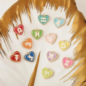 Set di ciondoli zodiacali a cuore dorato con smalto colorato su vassoio per gioielli