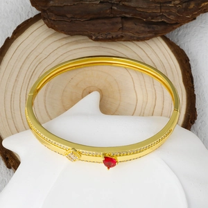 Luxurious gold-plated bangle with red heart stone and pavé zircon stones on white stone