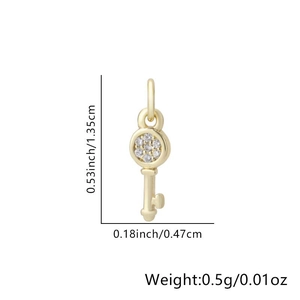 Dettaglio macro del ciondolo a chiave a cuore dorato con dimensioni 1,35 cm e pietre zirconi