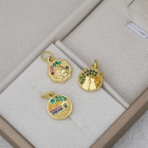 Tres colgantes redondos bañados en oro con circonitas de colores y motivos de gatos