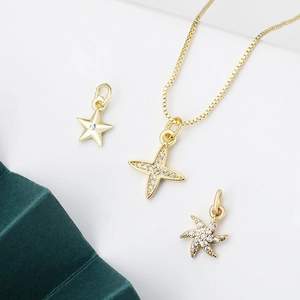 Set di collane con ciondoli a stella in oro 18K con cristalli su espositore verde