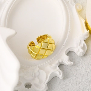 Anillo ajustable dorado minimalista con un refinado patrón de rombos en marco blanco