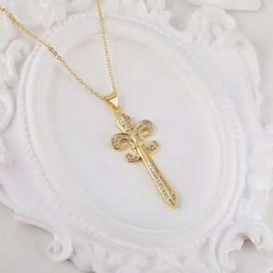 Collana dorata con giglio e spada e zirconi micro-pave su sfondo bianco a rilievo