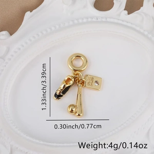 Detailed view of gold charms with ballet shoes and passport pendant measuring 3.39cm