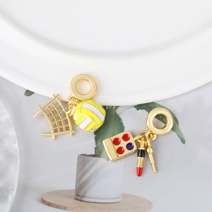 Enameled sports and makeup themed charm pendants for DIY bracelets on ceramic decor