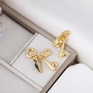 Golden sports charms featuring baseball bat, hat and sneaker on soft velvet jewelry box