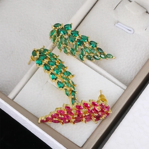 Gold-plated angel wing earrings with colorful green and red zircon stones in a box