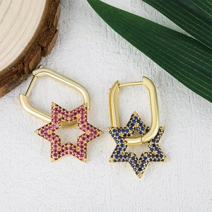 Pendientes de aro con estrella bañados en oro con circonitas de colores en un entorno natural
