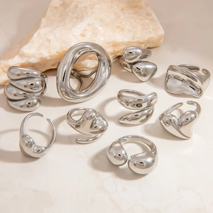 Detailweergave van zilveren minimalistische vloeibare metalen ringen op stenen display