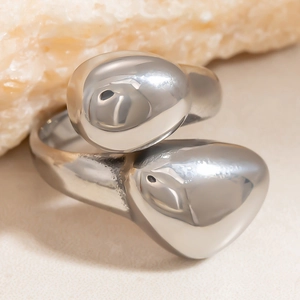 Macro-opname van zilveren asymmetrische open ring met druppelontwerp en spiegelglans
