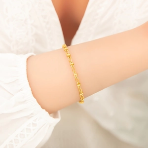 Nahaufnahme eines eleganten, 18 Karat vergoldeten Schlangenarmbandes am Handgelenk