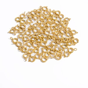 Pile of golden spring ring clasps for DIY jewelry making on a white background