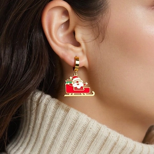 Detail of Christmas Santa Claus sled earrings in golden metal for festive fashion jewelry