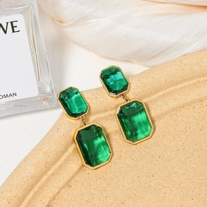 French vintage emerald rectangular earrings with gold frames on a silk background