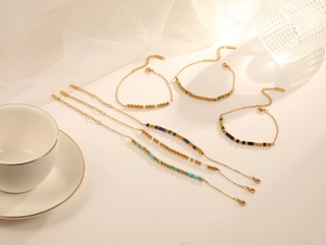 Ensemble élégant de bracelets en perles dorées et cristaux colorés sous une lumière douce