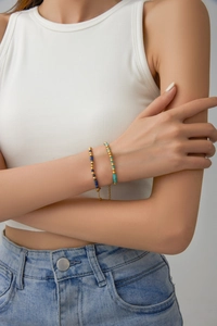 Bracelets en perles de lapis-lazuli et turquoise avec billes dorées portés au poignet