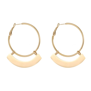 Macro-opname van gouden oorringen met gebogen geometrische hangers in gepolijste afwerking