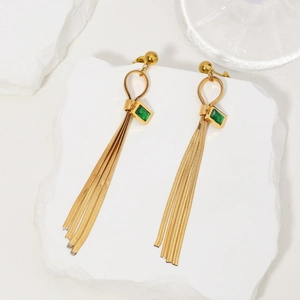 Detail of long gold tassel earrings with green crystal emerald cut gemstone inlays