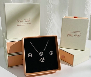 Detailed close-up of a silver jewelry set featuring cat-ear motifs in a premium gift box