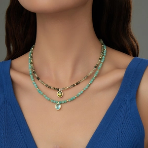 Close-up of double-layered beaded necklace featuring natural stone and oval gemstones