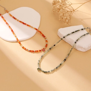 Close-up of elegant natural beaded necklaces with zircon pendants on a stone display