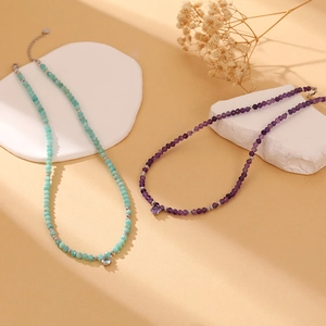 Detail of beaded gemstone necklaces with zircon pendants and silver spacers on stone