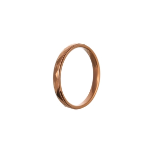 Dettaglio di un anello in oro rosa con superficie sfaccettata geometrica e design moderno
