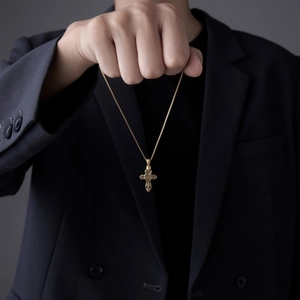 Collana urna a croce cava dorata con motivo a cuore su modello in abito nero elegante